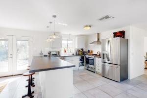 a kitchen with white cabinets and a stainless steel refrigerator at Lazy C Ranch in Tucson