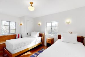 two beds in a room with white walls and windows at Lazy C Ranch in Tucson