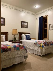 a bedroom with two beds and a table with a lamp at Oak Valley Inn and Suites in Geneseo