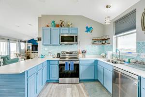 a blue kitchen with white countertops and blue cabinets at Times Like These in Galveston