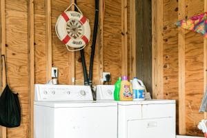 a washing machine in a room with a clock on the wall at Times Like These in Galveston +19 photos