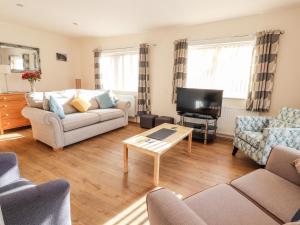 a living room with a couch and a tv at Awel Y Berwyn in Oswestry