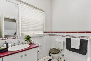 a white bathroom with a toilet and a sink at Court House - Studio in Beachport