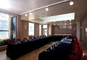 a long table in a room with red chairs at The Albatroz Hotel in Cascais +37 photos
