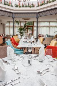 a dining room with tables and chairs with wine glasses at The Gonville Hotel, a member of Radisson Individuals in Cambridge