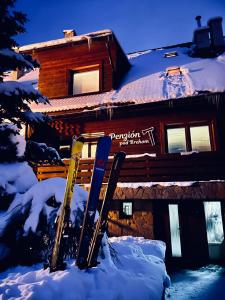 a group of skis in the snow in front of a building at Penzion pod Brehom in Terchová