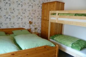 two bunk beds in a room with green sheets at Gasthof Zwilling in Schmallenberg