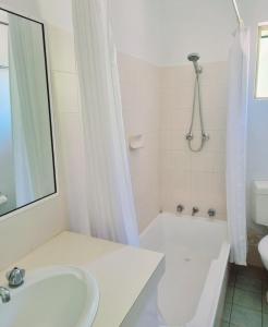 a white bath tub sitting next to a white sink at Bremer Bay Resort in Bremer Bay