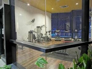 カジャンにあるKajang Town Homestay@ MKH Boulevard NETFLIX & WIFIのガラスの壁にエクササイズ機器が備わるジム