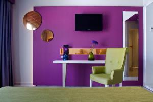 a purple wall with a white table and a yellow chair at The Purple Hotel - Adults Only in San Antonio