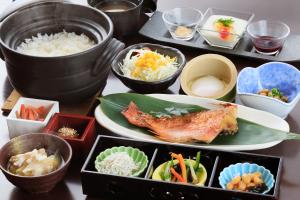 einen Tisch mit einem Teller mit Lebensmitteln und Schüsseln in der Unterkunft Yutoriro Bandai Atami in Koriyama