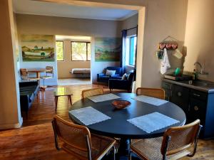 une cuisine et un salon avec une table et des chaises dans l'établissement Die Blouhuis Farmhouse Retreat with a hot tub, à Cloeteskraal