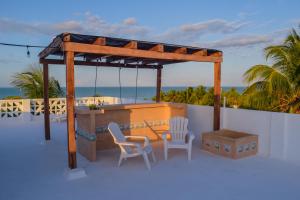 gazebo con due sedie e un tavolo e una scatola di Apartamentos Del Mar El Cuyo a El Cuyo