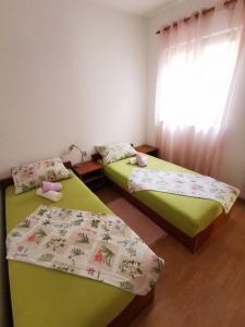 1 dormitorio con 2 camas y ventana en Apartment Goran - close to the sea, en Nečujam