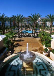 a fountain in the middle of a pool with palm trees at Universal's Loews Portofino Bay Hotel in Orlando