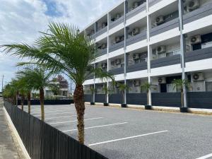 a parking lot with palm trees in front of a building at HYGGE Biimata in Nago