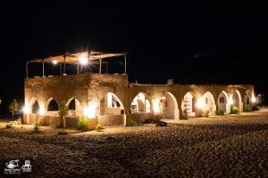 un edificio antiguo con luces en la noche en Hayaat siwa hot spring, en Siwa