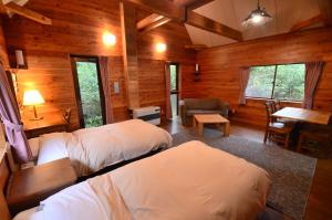 a bedroom with two beds in a log cabin at Nabekura Kougen Mori-No-Ie in Iiyama