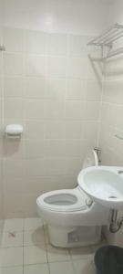 biała łazienka z toaletą i umywalką w obiekcie Tagaytay Prime Residence -Cityland w mieście Tagaytay