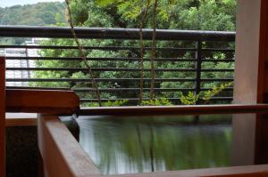 uma varanda com vista para o rio em Toushinan Komeya em Ito