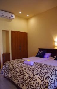 a bedroom with a large bed with a purple and white blanket at Pondok Mangga in Mataram