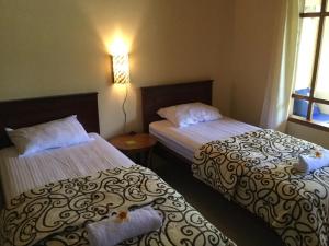 a hotel room with two beds and a window at Pondok Mangga in Mataram