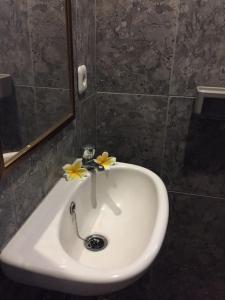 a white sink with flowers on it in a bathroom at Pondok Mangga in Mataram +15 photos