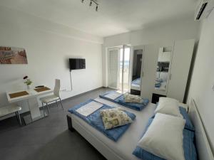 a bedroom with two beds and a table and a desk at Apartments Nevistic in Podstrana