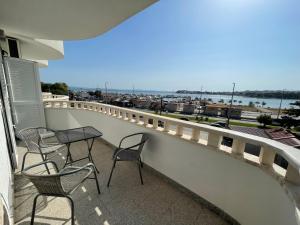 a balcony with chairs and a table and a view of the water at Apartments Nevistic in Podstrana