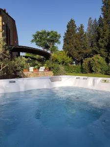 uma piscina com água azul num quintal em La Casa di Manuela, Villa Indipendente nel Chianti con Vasca Idromassaggio em Barberino di Val dʼElsa