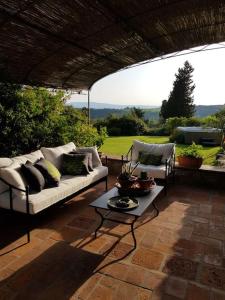 a patio with a couch and a coffee table at La Casa di Manuela, Villa Indipendente nel Chianti con Vasca Idromassaggio in Barberino di Val dʼElsa