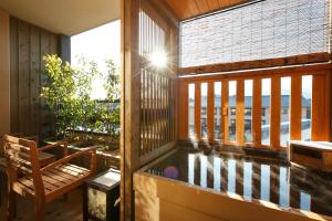 a balcony with a pool of water and a chair at Tokinoniwa in Kusatsu