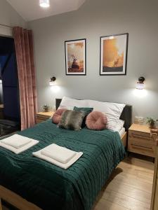 1 dormitorio con 1 cama verde y 2 almohadas en Apartament Silence Karpatia Resort Aleksandryt, en Karpacz