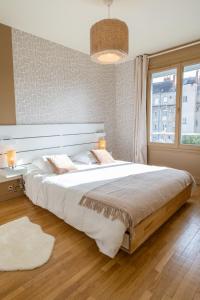 Un dormitorio con una cama grande y una ventana en Tours Centre - Proche Gare - Parking Vélo - Balcon - Arrivée autonome, en Tours