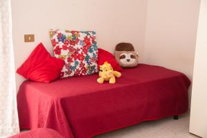 una cama roja con dos animales de peluche encima en Panta rei en Mentana