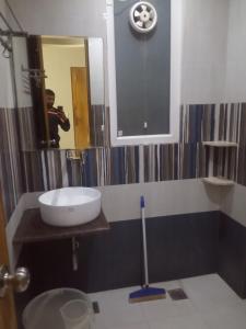 a man taking a picture of a bathroom with a sink at Hotel veersarthak residency in Hisār