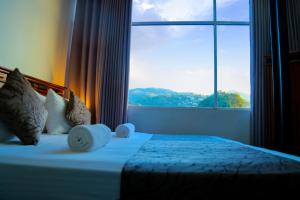 1 dormitorio con 1 cama y ventana grande en Kandy Tower Inn, en Kandy