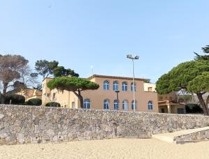 - un bâtiment sur la plage avec un mur en pierre dans l'établissement Apartamento con jardín a 11 metros de la playa. B3., à Palamós