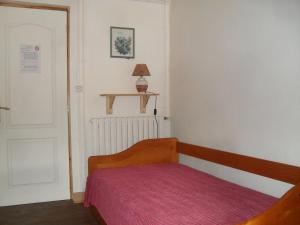 プロンビエール・レ・バンにあるAppartements -2 Rue des Sybilles-La Plombinoiseの小さなベッドルーム(赤い毛布付きのベッド付)
