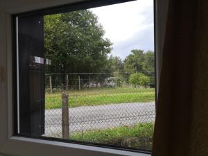 a window with a view of a fence and a road at Studio Bellevue in Égletons