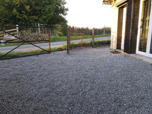 a gate in a gravel driveway next to a house at Studio Bellevue in Égletons