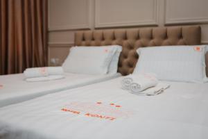 戈里察Hotel Konti的酒店房间有两张床，床单是白色的