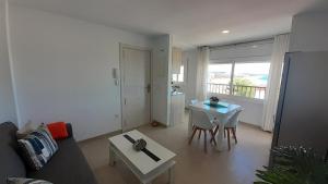 Apartamentos Dins Mar Apto. 11 في توريديمبارا: غرفة معيشة مع أريكة وطاولة