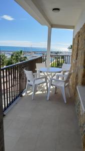 eine Terrasse mit einem Tisch und Stühlen auf dem Balkon in der Unterkunft Apartamentos Dins Mar Apto. 11 in Torredembarra