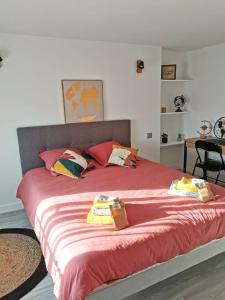 ein Schlafzimmer mit einem großen Bett mit roter Bettwäsche und Kissen in der Unterkunft Just Suite Home - Superbe 2 pièces entre Paris et Orly, jardin privé in Villeneuve-Saint-Georges