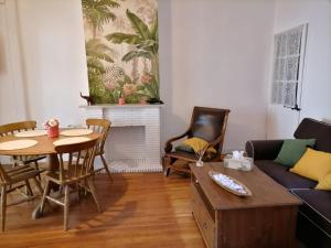 ein Wohnzimmer mit einem Tisch und einem Sofa in der Unterkunft Le grand Houx in Orthez