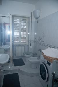 een witte badkamer met een wasmachine bij 'Panta rei' in Mentana