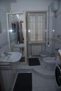 een witte badkamer met een wastafel en een toilet bij 'Panta rei' in Mentana