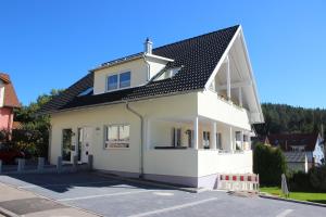 a white house with a black roof at Steppacher Ferienappartements in Friedenweiler