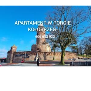 a person standing in front of a building at Apartament w Porcie in Kołobrzeg